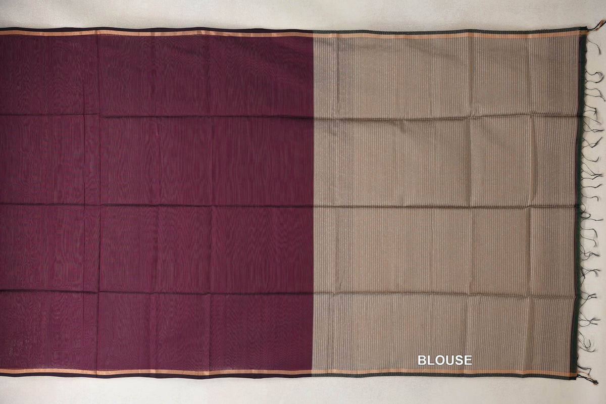 Maheshwari silk cotton saree laid flat, with a wine maroon body, narrow borders and a sand beige striped blouse section with tassels.