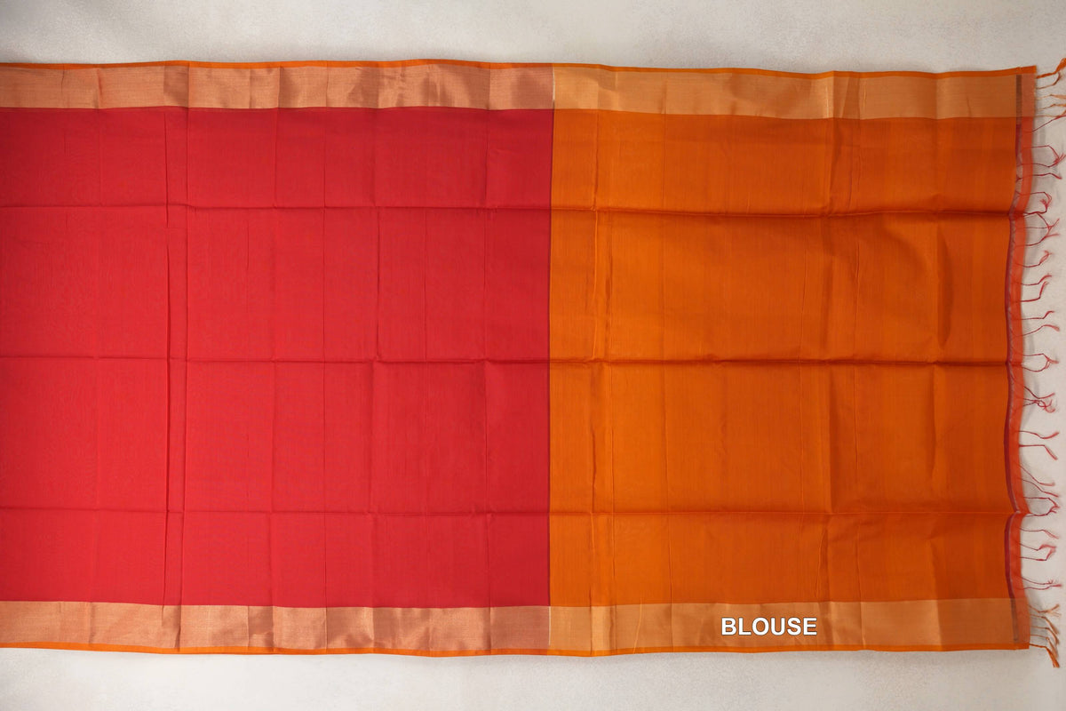 Unfolded Maheshwari silk cotton saree showing a plain tomato red body beside a deep orange blouse section, with selvedge borders and tassels.