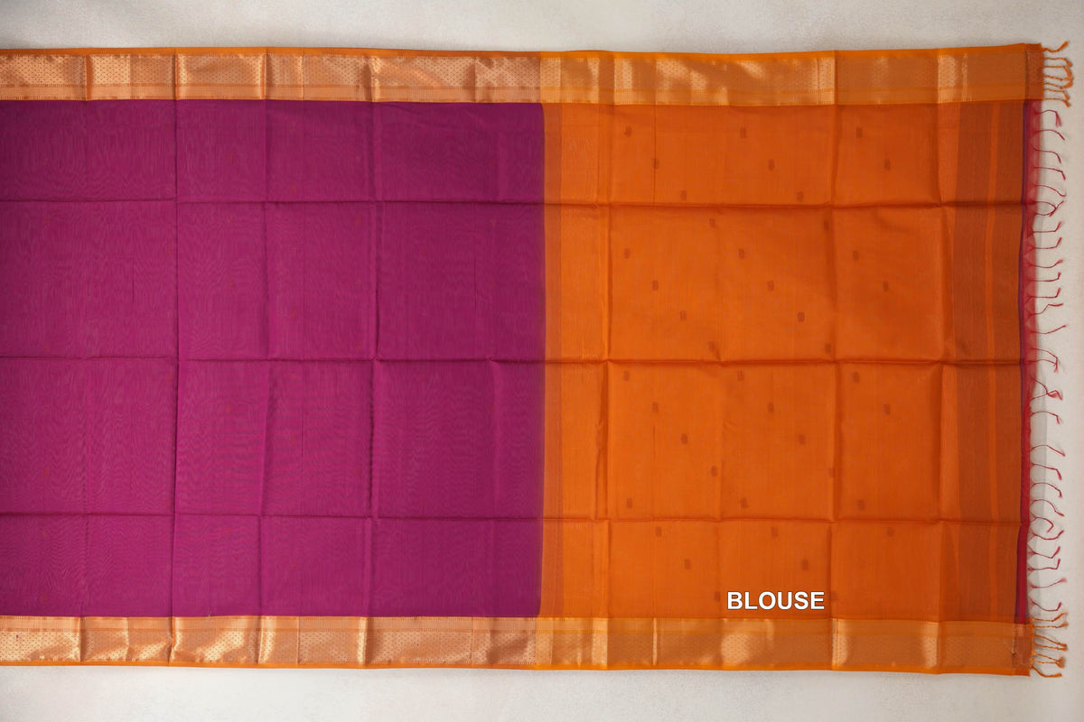 Maheshwari silk cotton saree laid flat, showing a dark magenta body, deep orange borders, and a deep orange blouse section with small dots and tassels.
