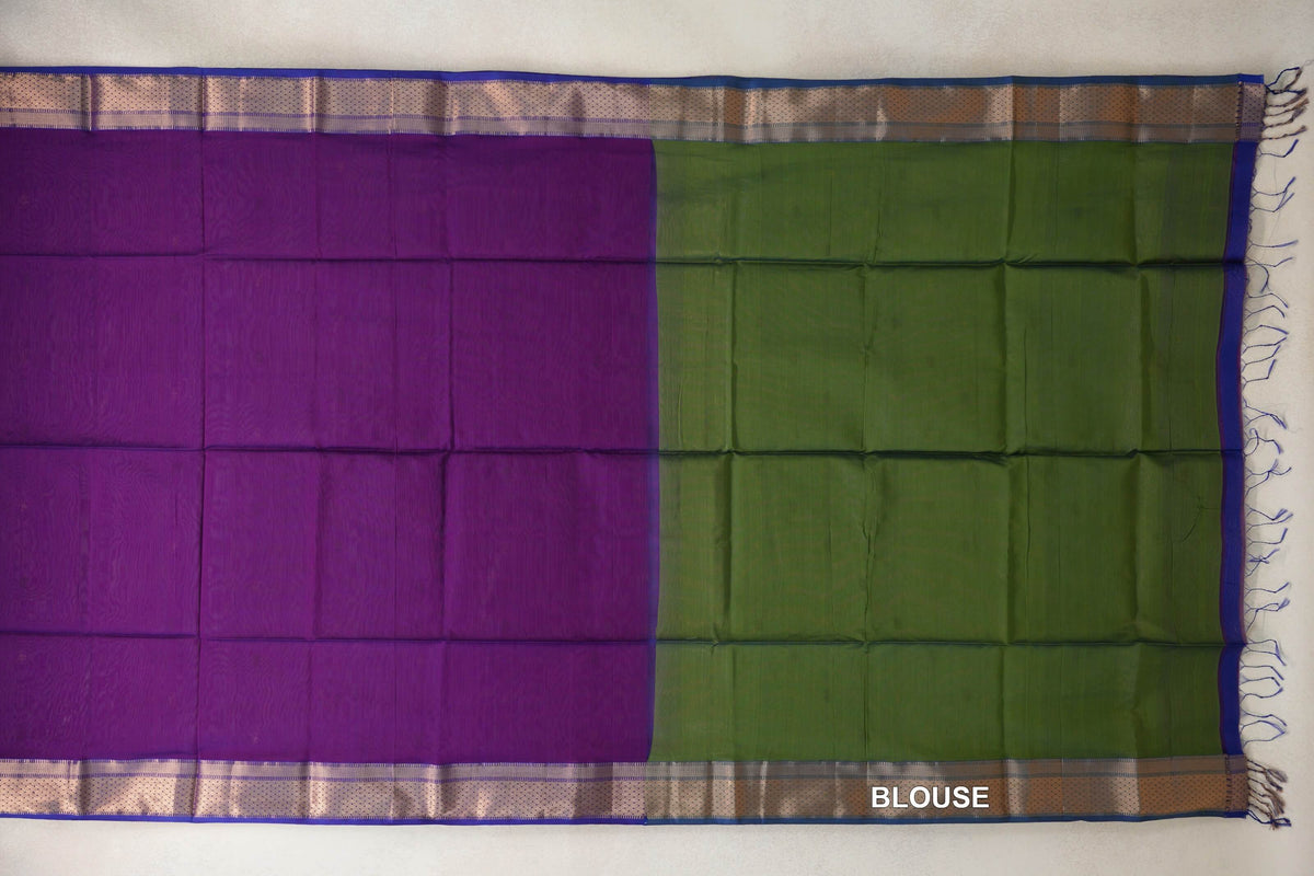 Maheshwari silk cotton saree laid flat, showing a violet purple body beside an olive green blouse panel, with patterned royal blue borders and tassels.