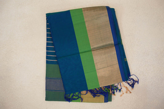 Folded peacock blue Maheshwari silk-cotton saree showing a parrot green band, broad gold-toned pallu, royal blue edge and Multi Color tassels.