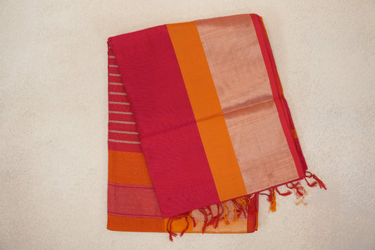 Folded Maheshwari silk cotton saree showing deep rani pink fabric, a deep orange band, a pale pink panel and tasselled edges.