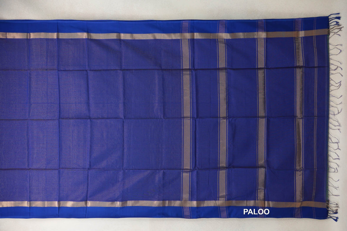 Deep royal blue Maheshwari silk-cotton saree laid flat, showing silver-toned borders, a striped pallu and blue tassels.