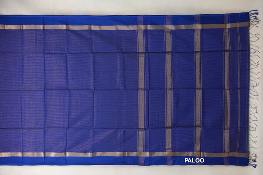 Deep royal blue Maheshwari silk-cotton saree laid flat, showing silver-toned borders, a striped pallu and blue tassels.