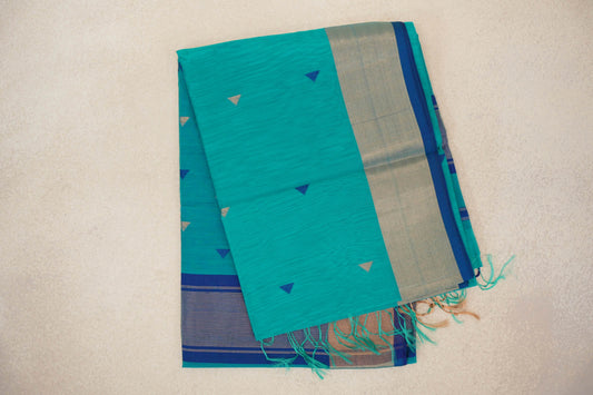 Folded bright turquoise green Maheshwari silk-cotton saree with small blue and gold triangles, a light metallic border, Classic Blue edging and tassels.