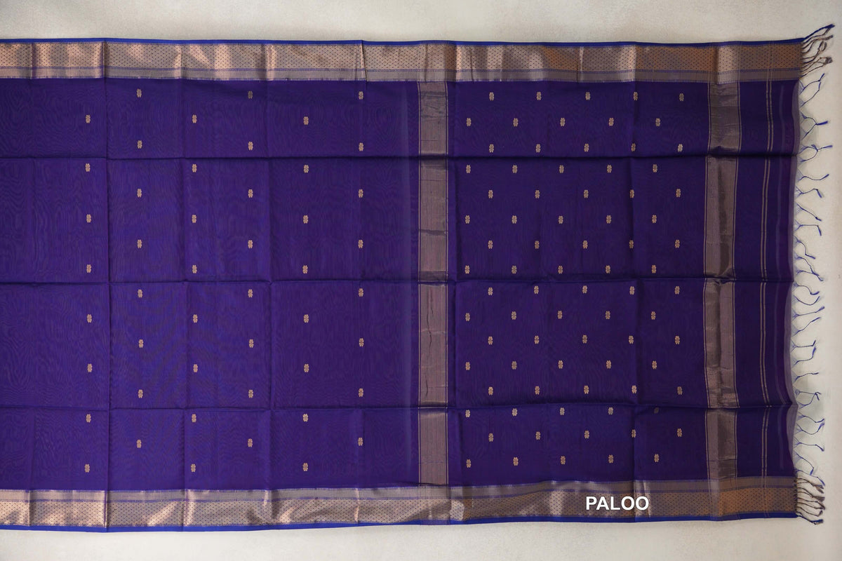 Royal Purple Maheshwari silk cotton saree spread out, with small gold-toned motifs, patterned borders and a tasseled pallu at the right.