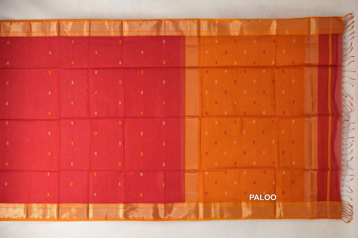 Maheshwari silk cotton saree spread flat, with a tomato red body, mustard orange pallu, small dotted motifs, woven borders and tassels.