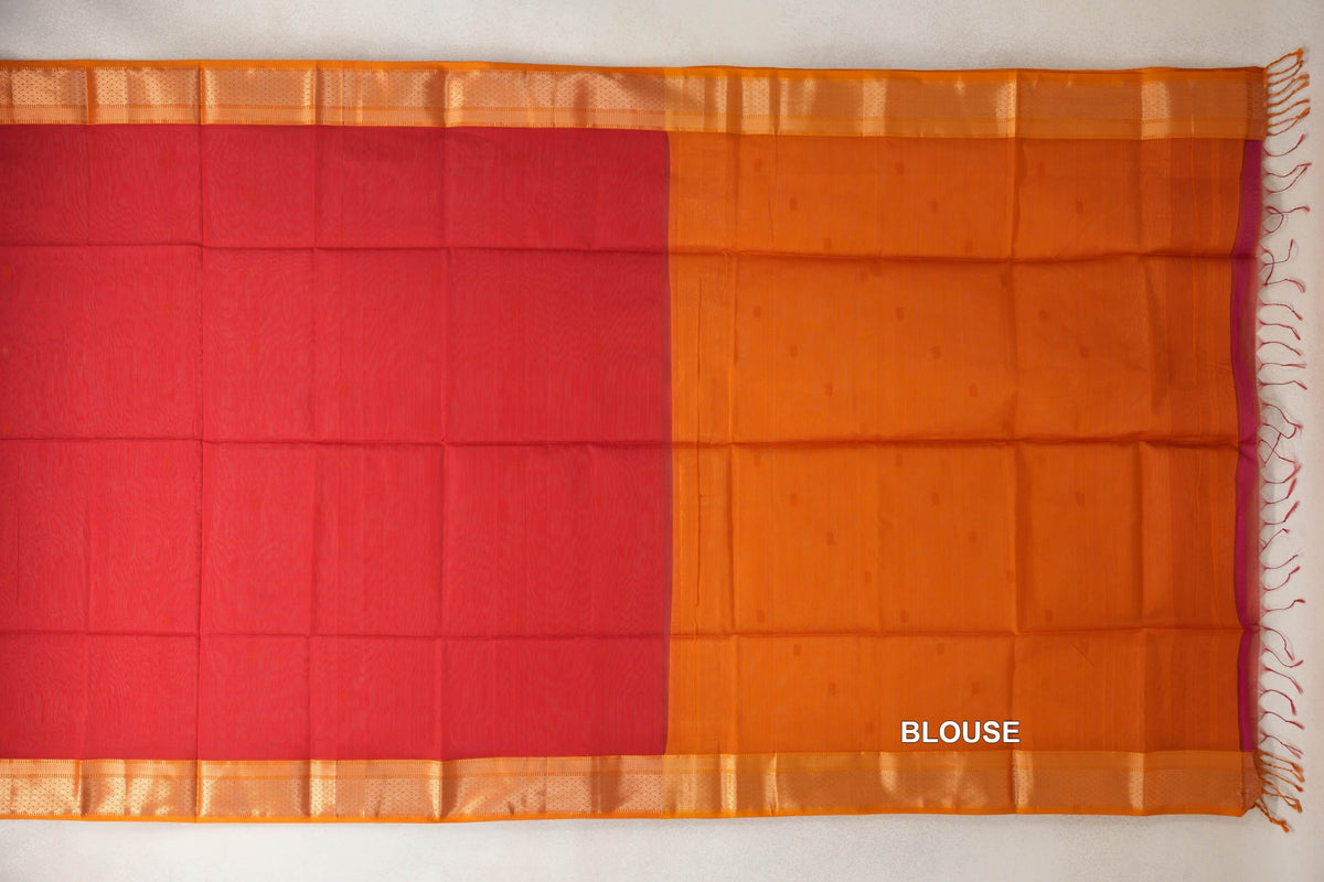 Maheshwari silk cotton saree laid flat, showing a tomato red body beside the mustard orange blouse section, with patterned orange borders and end tassels.