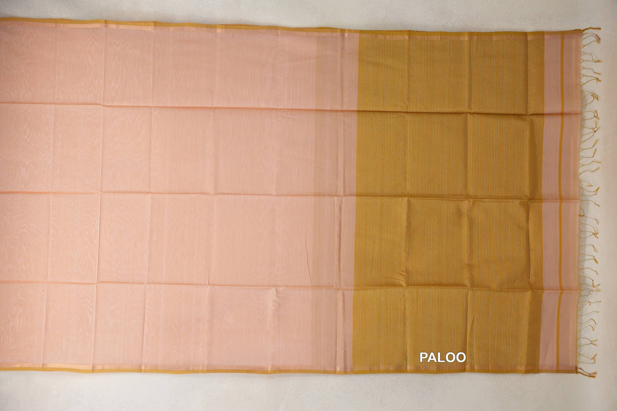 Peach Maheshwari silk cotton saree spread flat, with slim light mustard gold borders and a finely striped pallu ending in tassels.