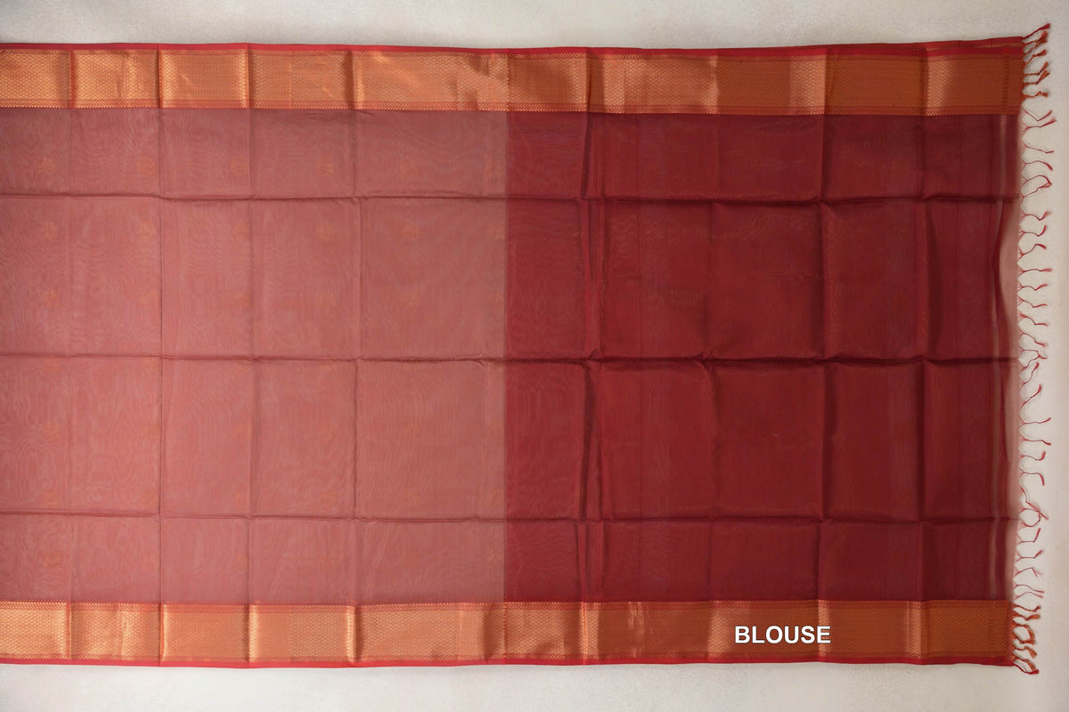 Dusty Rose Maheshwari silk cotton saree spread flat, with a brick red blouse section on the right, woven borders, red selvedge and tassels.