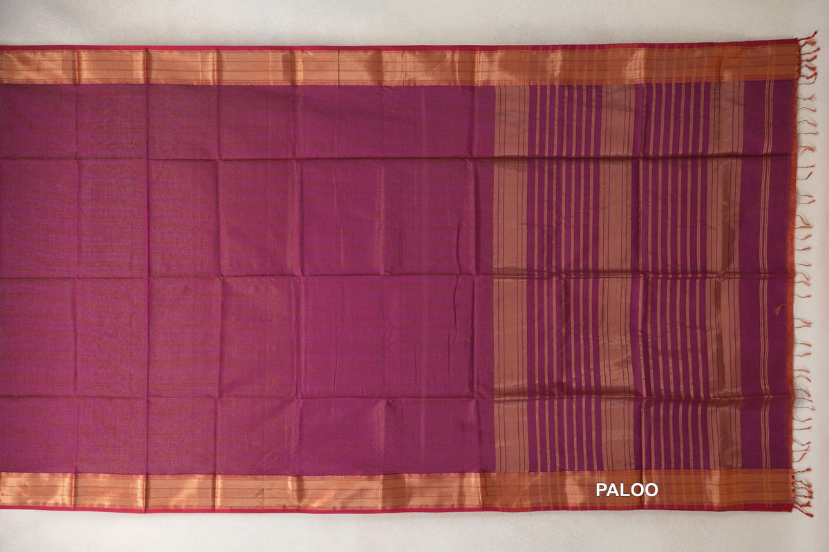 Deep Magenta Maheshwari silk cotton saree laid flat, showing a plain body, striped pallu, shimmering borders with Rani Pink edges, and tassels.