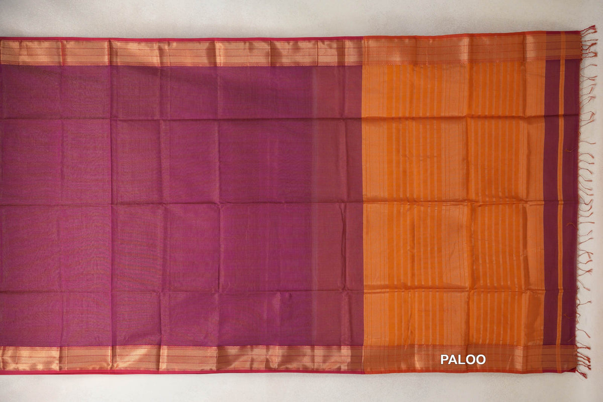 Maheshwari silk cotton saree spread flat, showing a plain deep magenta body, rani pink-edged borders and a striped deep orange pallu with tassels.