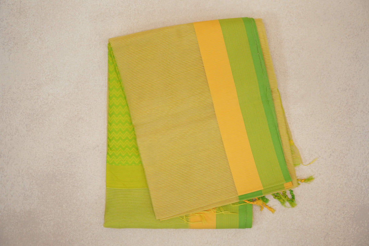 Folded lemon yellow Maheshwari silk cotton saree with fine stripes, a yellow and parrot green border, a green zigzag panel and tassels.
