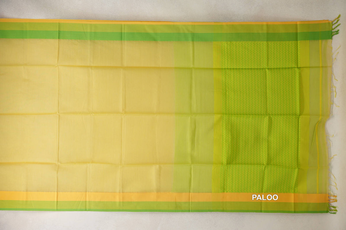 Maheshwari silk cotton saree laid flat, showing a lemon yellow body, parrot green and yellow borders, and a patterned pallu with tassels.