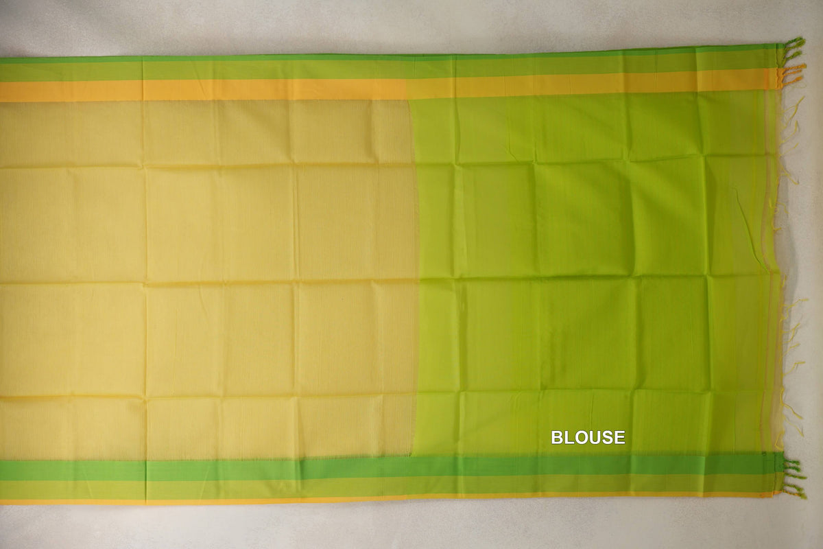 Saree laid flat, showing a lemon yellow silk cotton body, parrot green and yellow borders, and a lime green blouse piece on the right.