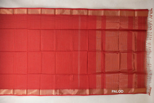 Tomato red Maheshwari silk cotton saree spread flat, showing a fine checked body, gold zari borders and a striped pallu with tassels.