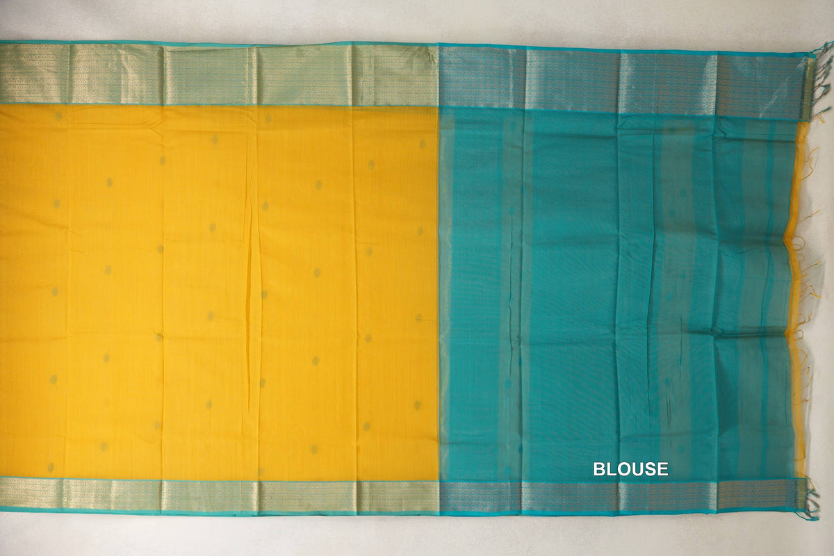Laid-out mango yellow Maheshwari silk cotton saree with scattered dots, patterned turquoise blue borders and a turquoise blue blouse section on the right.