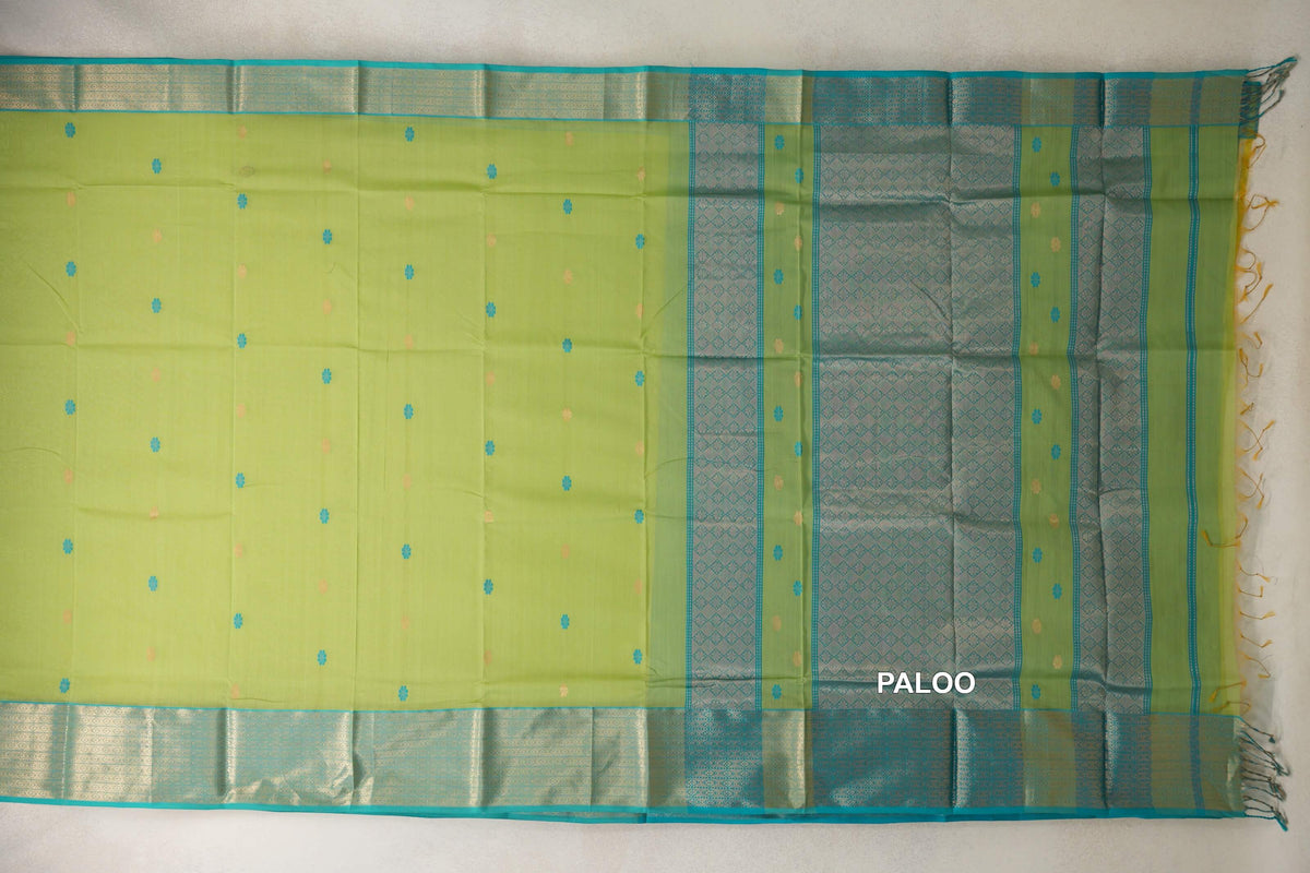 Maheshwari silk cotton saree laid flat, with a lime green body dotted with small motifs, turquoise blue patterned borders and a tasseled pallu.