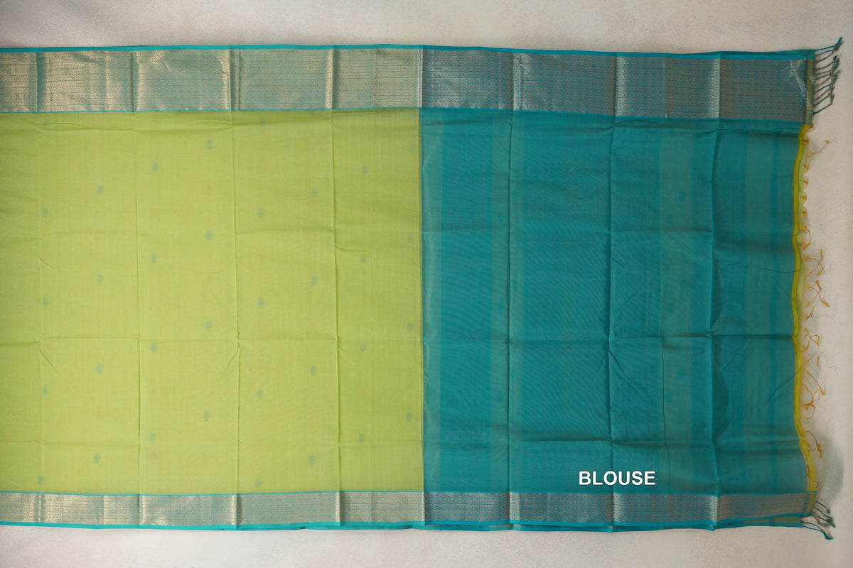 Maheshwari silk cotton saree spread flat, showing a lime green body with small turquoise dots, patterned turquoise borders and a turquoise blouse section.