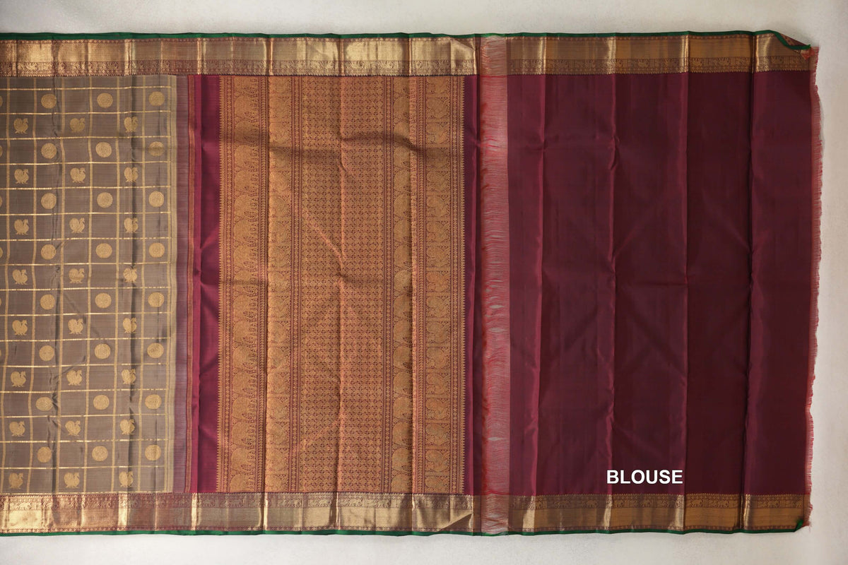Kanjivaram silk saree laid out with an olive green checked body, ornate deep maroon pallu, matching blouse fabric and gold borders edged in bottle green.