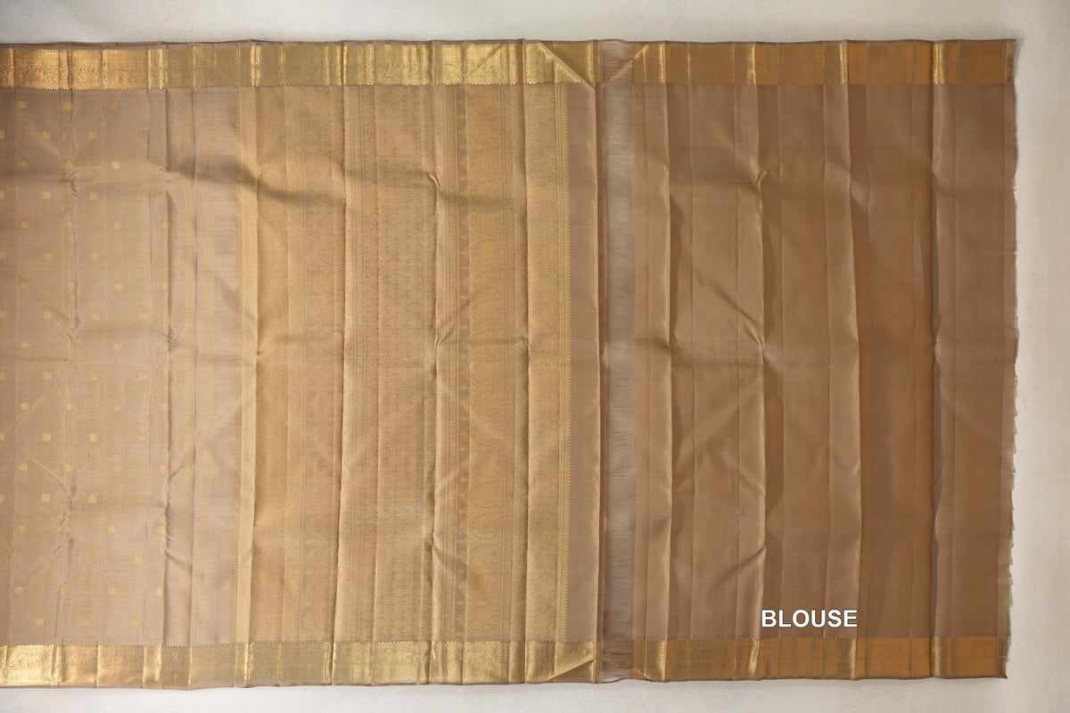 Greenish beige vintage Kanjivaram silk saree laid flat, showing a dotted body, patterned zari pallu and borders, and matching blouse piece at right.