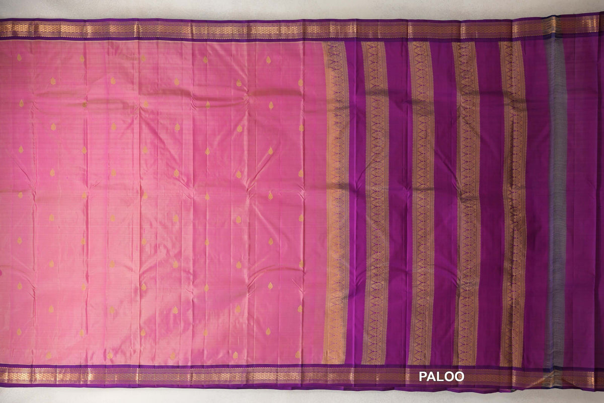 Lightweight Kanchipuram silk saree spread out, with a rose pink body dotted with gold motifs, purple borders and a purple pallu with gold patterned stripes.