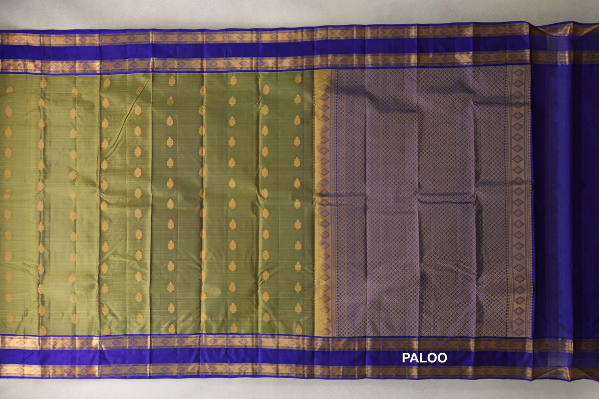 Lightweight Kanchipuram silk saree spread open, with gold motifs on an olive green body, royal blue borders and a densely patterned pallu.
