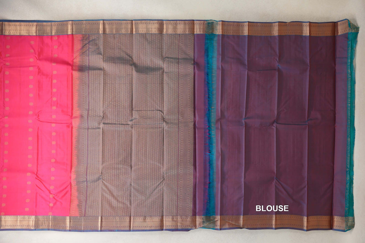 Lightweight Kanchipuram silk saree laid out with a rani pink body, small gold motifs, a patterned teal blue pallu, gold-toned borders and blouse fabric at right.