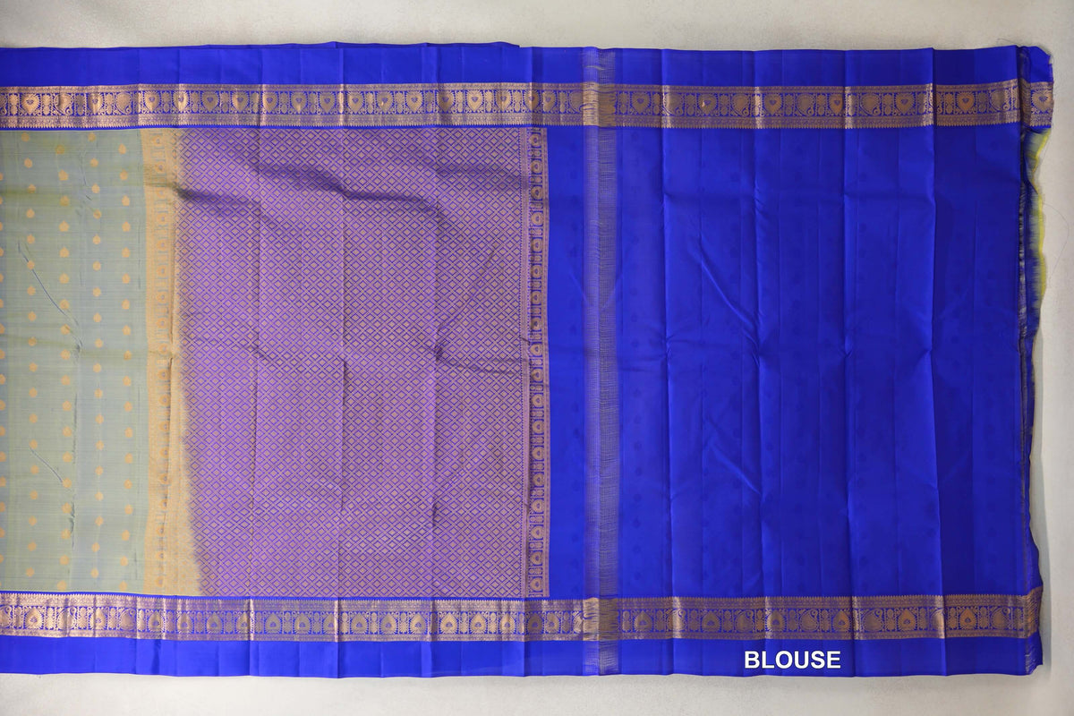 Laid-out lightweight Kanchipuram silk saree with a yellowish green dotted body, a gold lattice pallu, royal blue borders and matching blouse fabric.