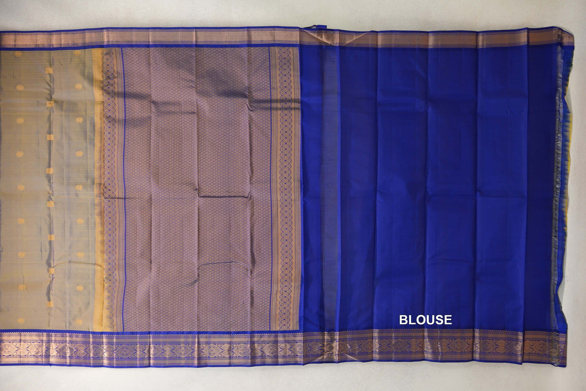 Lightweight Kanchipuram silk saree laid flat, showing a yellow and violet body, patterned pallu and deep royal blue blouse with gold-patterned borders.