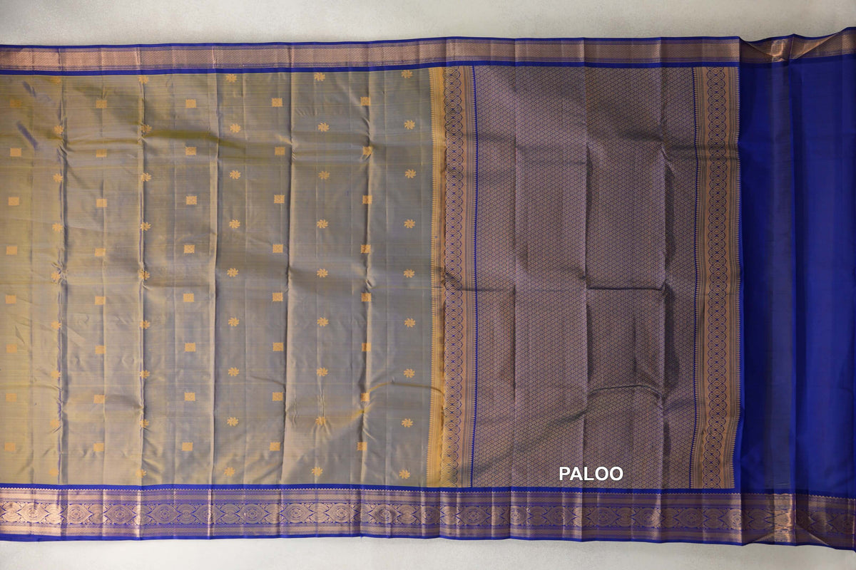 Lightweight Kanchipuram silk saree spread out, with a yellow and violet body dotted with gold motifs, deep royal blue borders and a patterned pallu.