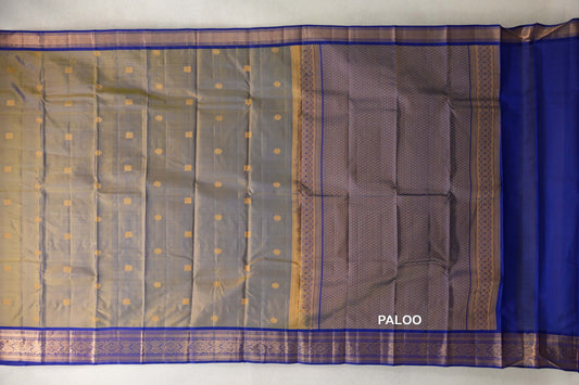 Lightweight Kanchipuram silk saree spread out, with a yellow and violet body dotted with gold motifs, deep royal blue borders and a patterned pallu.