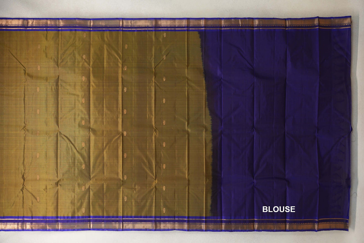Spread-out olive green Kanchipuram silk saree with small gold motifs and deep royal blue borders, alongside a matching blue blouse piece.