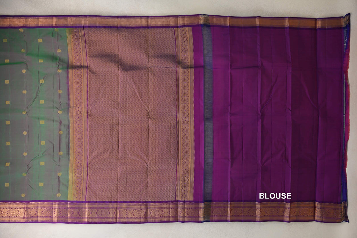 Lightweight Kanchipuram silk saree laid open, showing a green body with small gold motifs, a patterned violet purple pallu and borders, and matching blouse fabric.