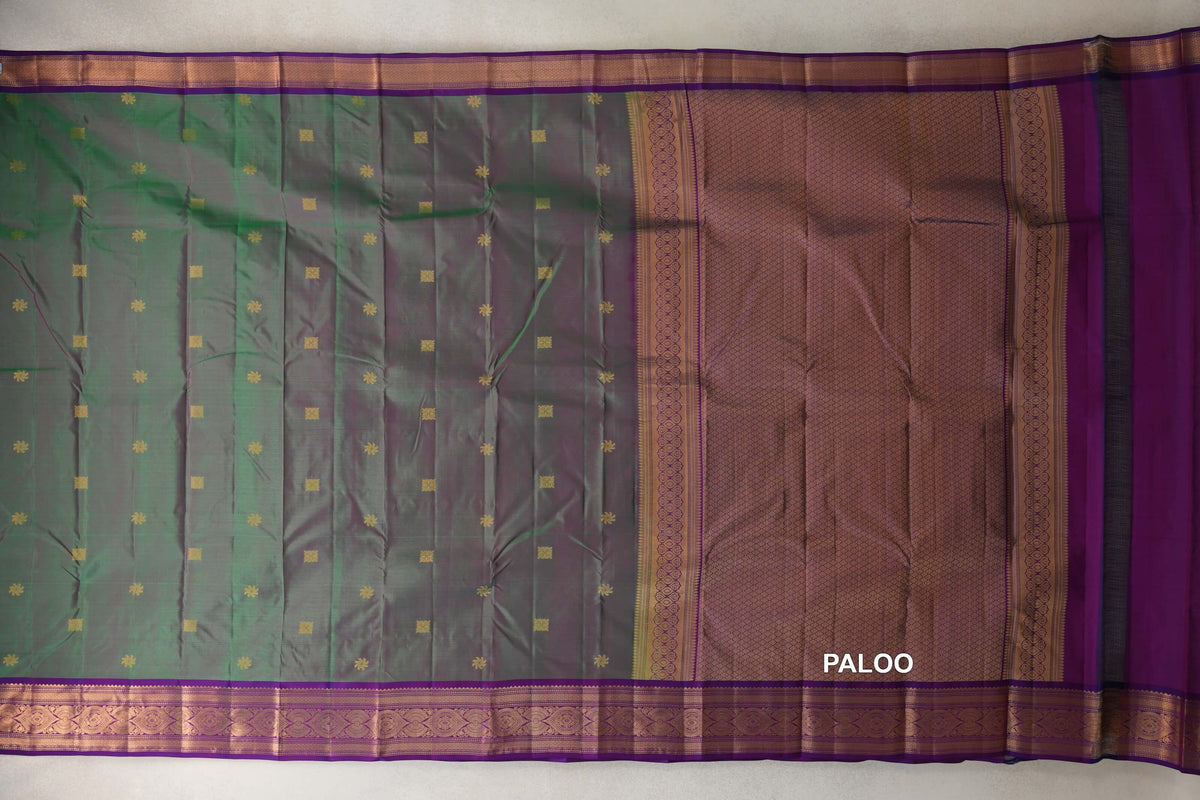 Lightweight Kanchipuram silk saree spread flat, with a green and pink body, small gold motifs, violet purple borders and a lattice-patterned pallu.