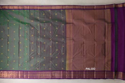 Lightweight Kanchipuram silk saree spread flat, with a green and pink body, small gold motifs, violet purple borders and a lattice-patterned pallu.
