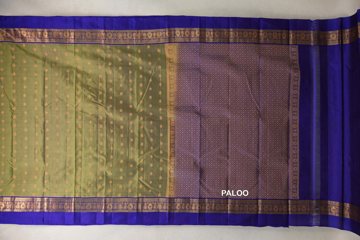 Lightweight Kanchipuram silk saree laid flat, showing an olive green body with gold dots, royal purple borders and a lattice-patterned pallu.