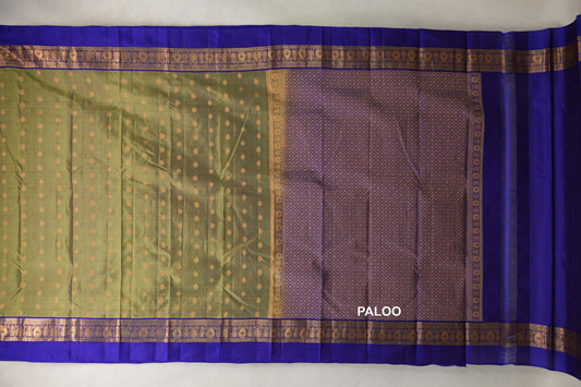 Lightweight Kanchipuram silk saree laid flat, showing an olive green body with gold dots, royal purple borders and a lattice-patterned pallu.