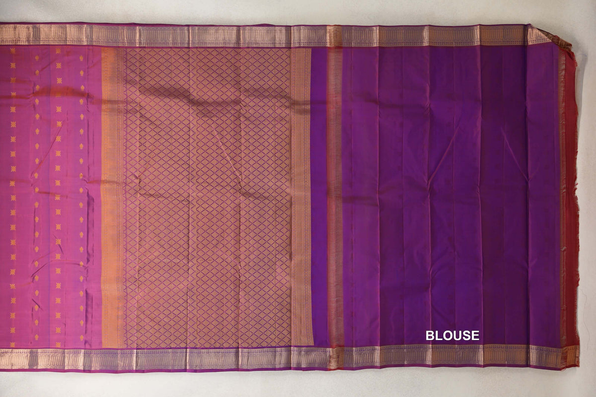 Blue and red Kanchipuram silk saree laid flat, showing a gold lattice pallu, small body motifs, ornate borders and a plain blouse panel.