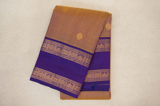 Folded lightweight Kanchipuram silk saree with a striped mustard yellow body, scattered gold motifs and deep purple borders with gold floral patterns.