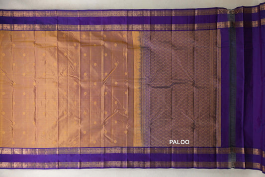 Kanchipuram silk saree laid open, showing a mustard yellow body with small motifs, deep purple patterned borders and a geometric pallu.
