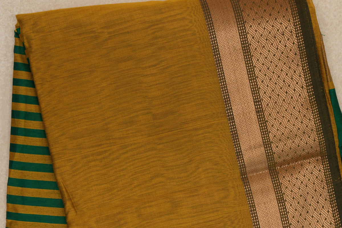 Folded Maheshwari silk-cotton saree with a mustard yellow body, an emerald green and mustard striped pallu, and a patterned green border.