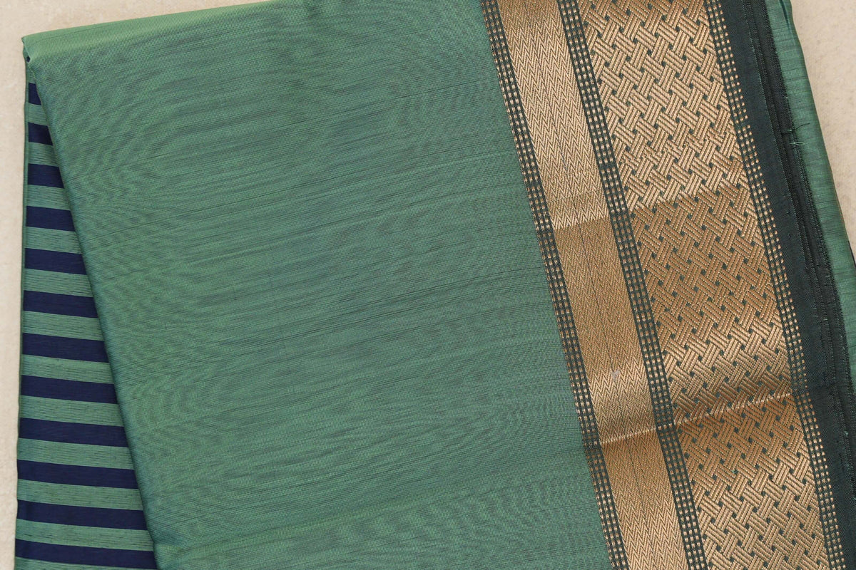 Folded sea green Maheshwari silk cotton saree with a dark sea green border woven in gold zari; navy blue and sea green stripes peek out at the side.