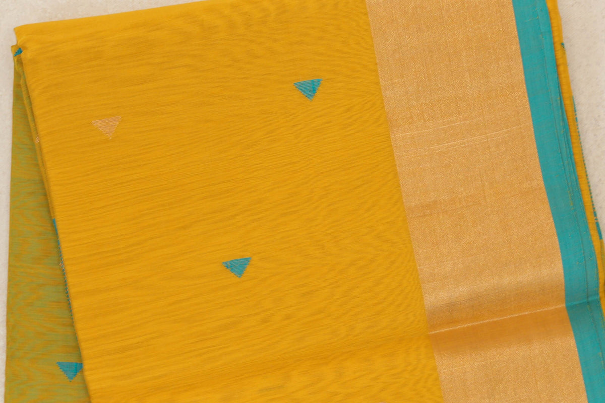 Folded Maheshwari silk-cotton saree with a mustard yellow body, scattered turquoise triangle motifs and a broad gold-toned border edged in turquoise blue.