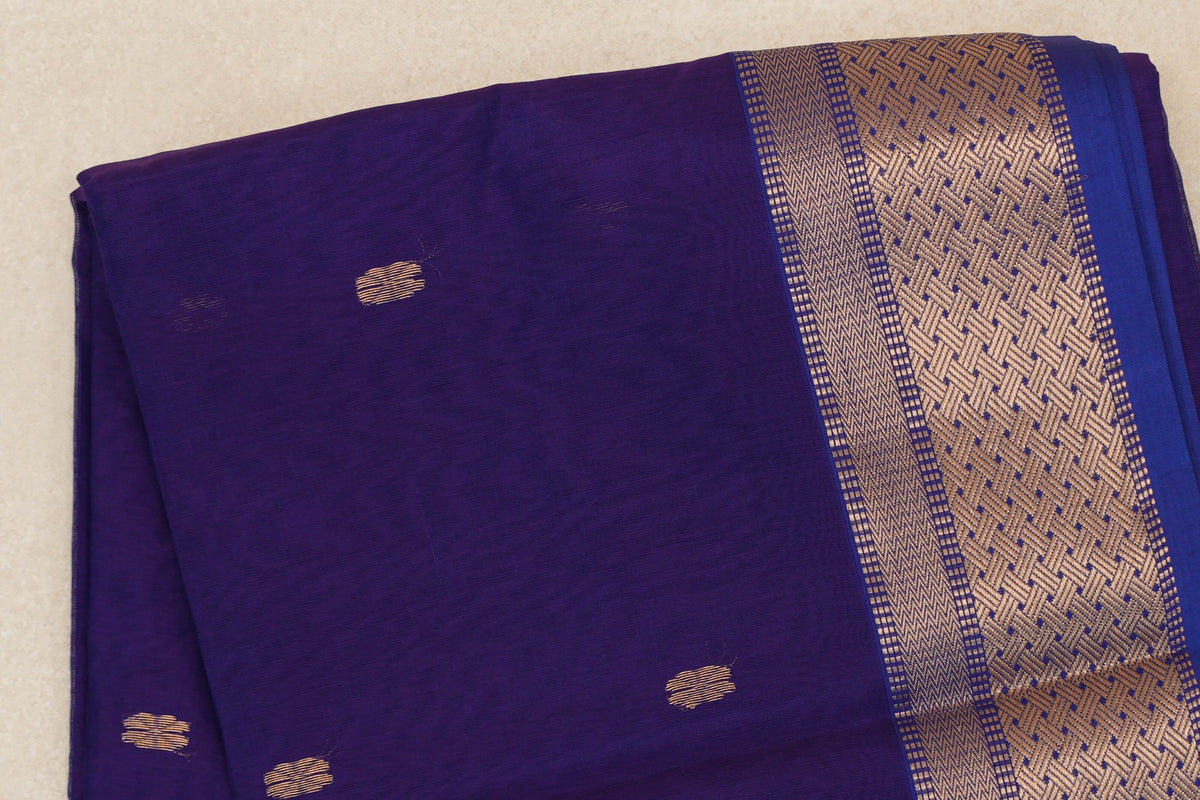 Folded royal purple Maheshwari silk cotton saree showing a body with scattered small gold motifs and a wide geometric gold border.