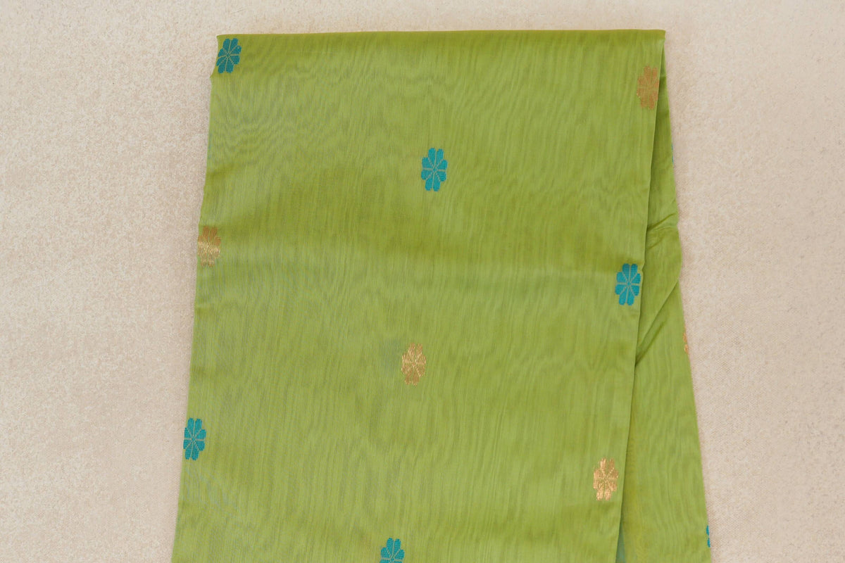 Folded lime green Maheshwari silk cotton saree body with scattered turquoise blue and gold floral motifs.