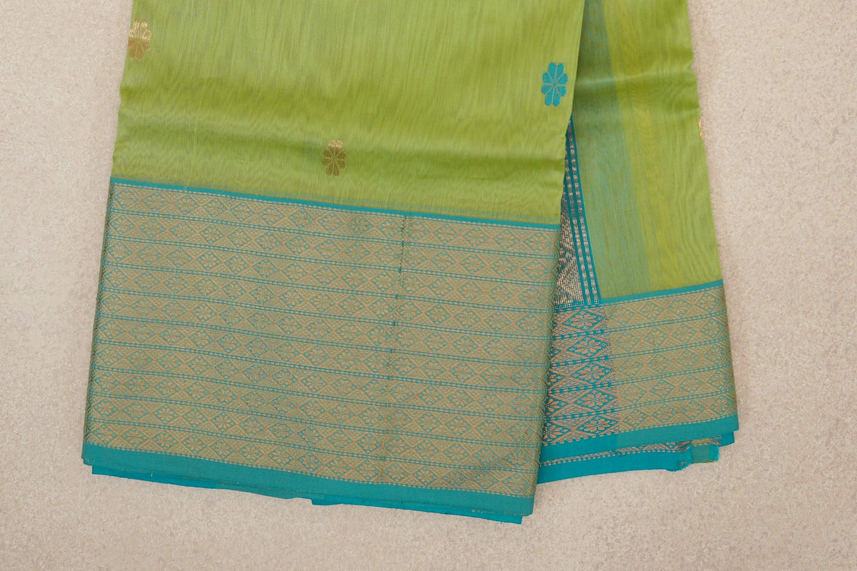 Folded lime green Maheshwari silk cotton saree with small turquoise and gold motifs and a wide turquoise blue border with gold diamond patterns.