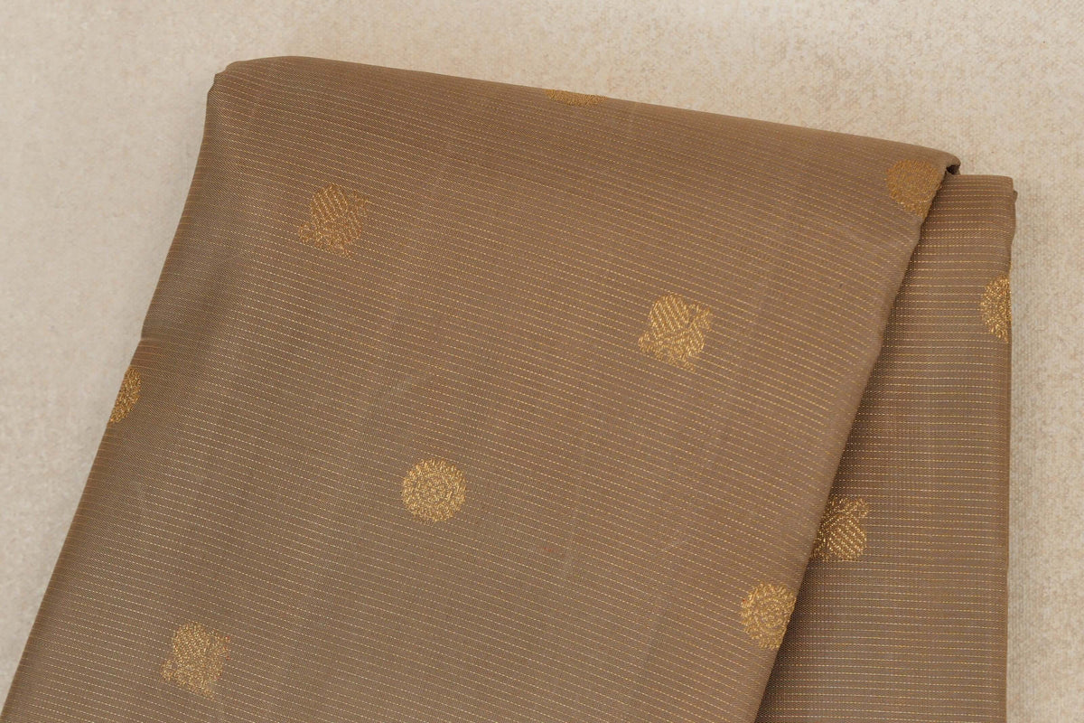 Folded greenish beige vintage Kanjivaram silk saree with fine gold stripes and scattered small gold motifs.