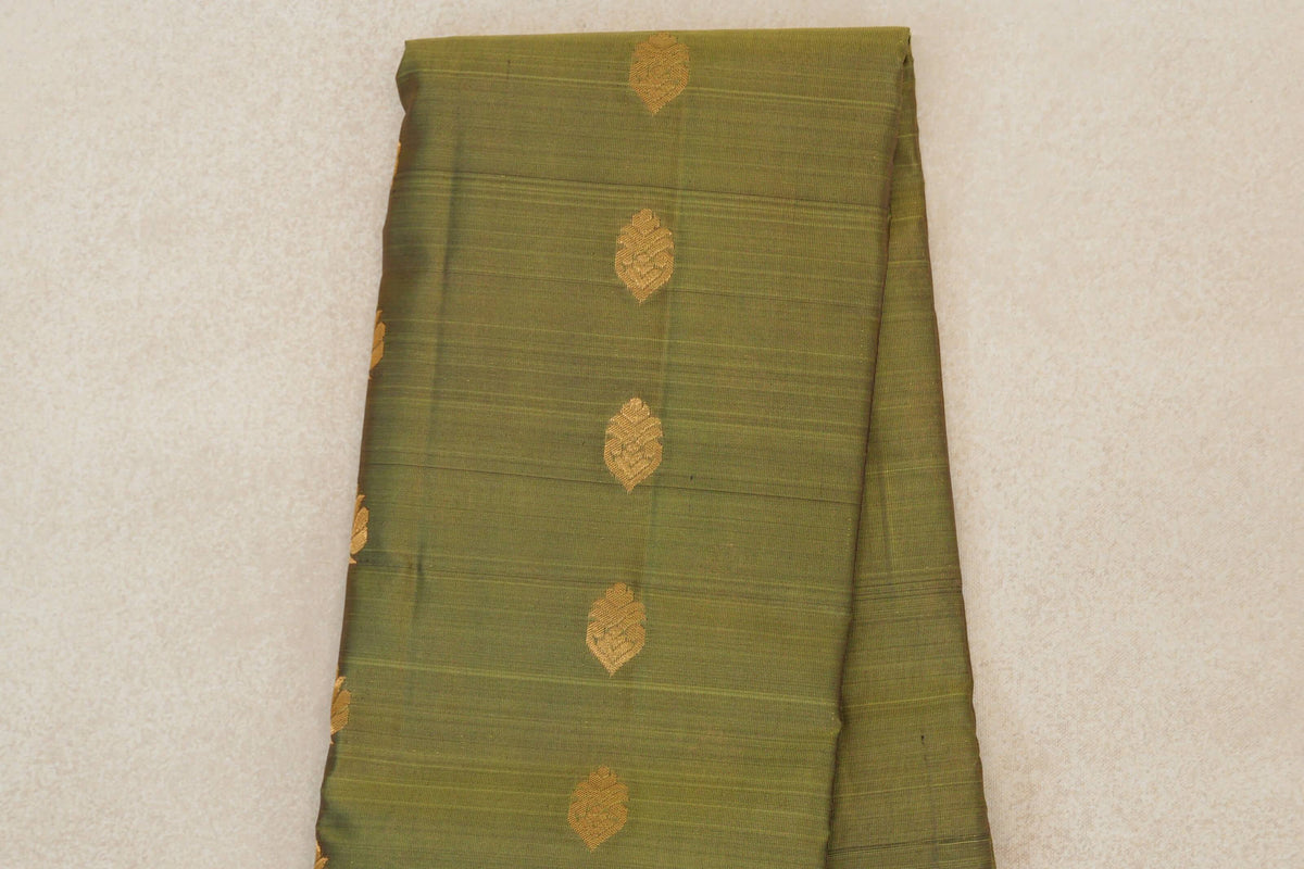 Folded olive green lightweight Kanchipuram silk saree body with spaced gold motifs and fine horizontal lines.