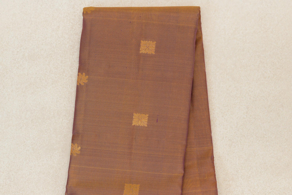 Folded lightweight Kanchipuram silk saree showing its magenta and yellow body with spaced gold square motifs and fine horizontal lines.